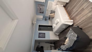 A room with a bed, a dresser, a mirror, and a window.