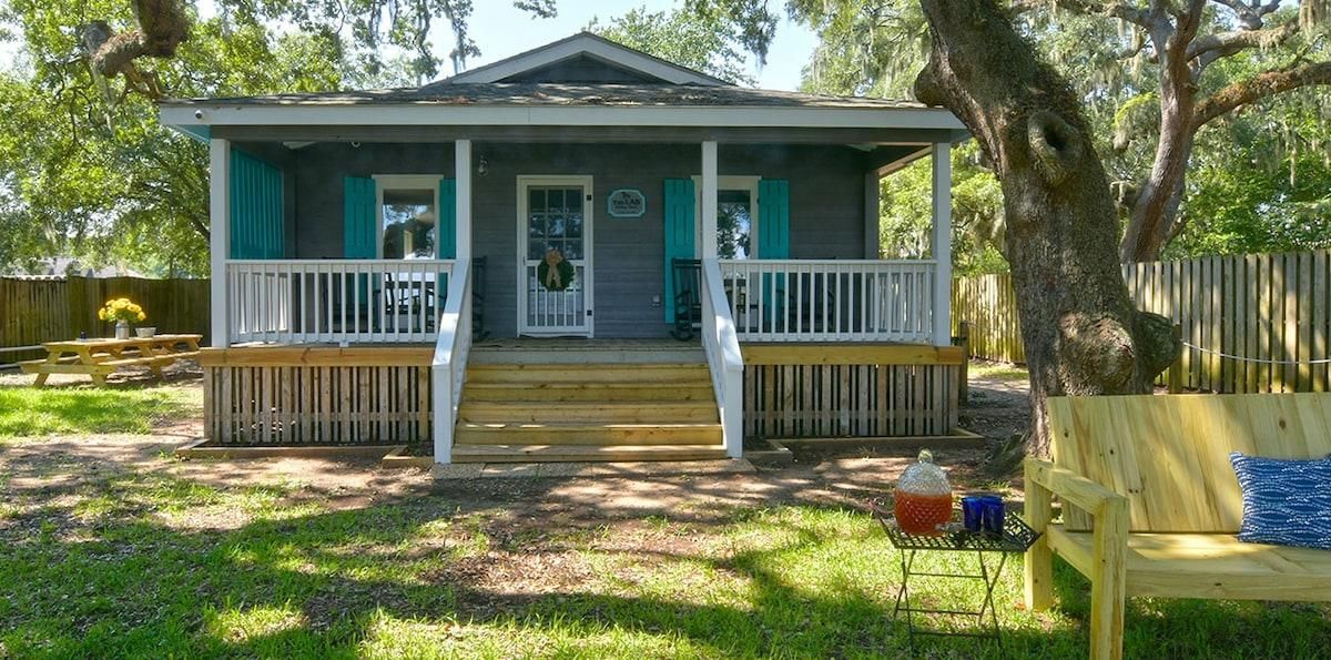 A single-story house with a porch, a front door, and a small front yard.