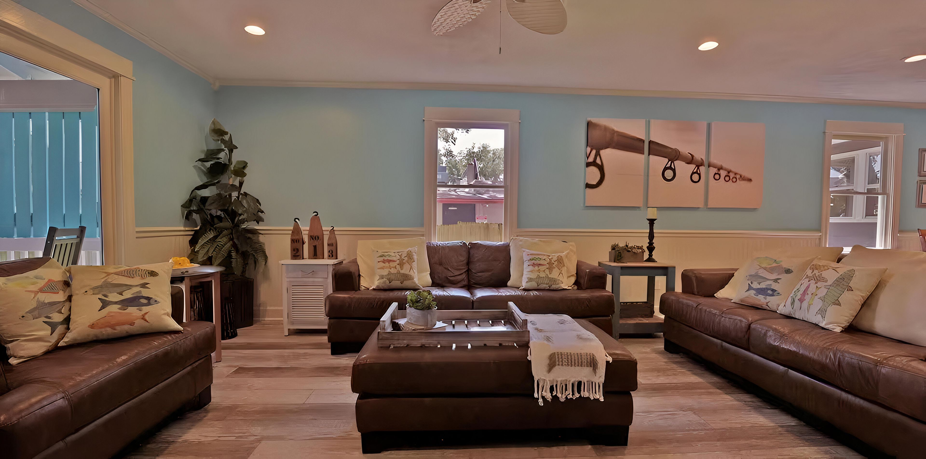 A living room with two brown leather sofas, a coffee table, and a large plant.