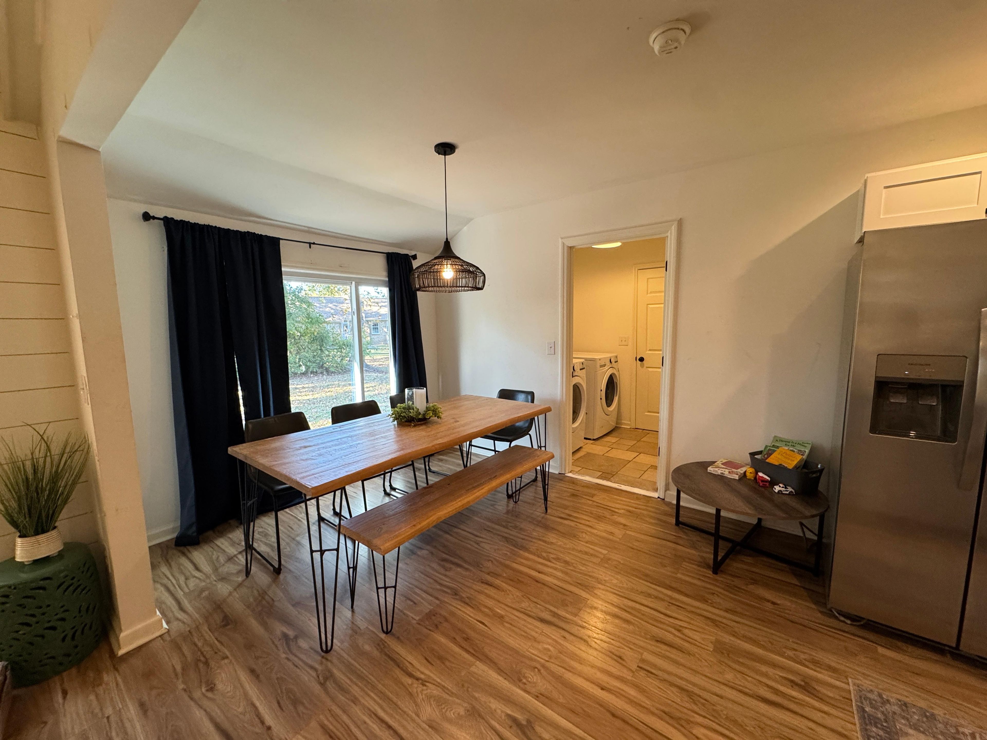 Eine moderne Küche mit einem Holztisch, einer eingebauten Waschmaschine und einem Edelstahlkühlschrank.
