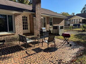 A patio with brick flooring, outdoor furniture, and a grill. - Plush in the Pines!  - 4BR + Game Room (Ladson)