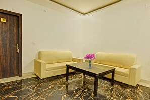 A room with two sofas, a coffee table, and a door. - Collection O Mountain View Resort (Ranchi)