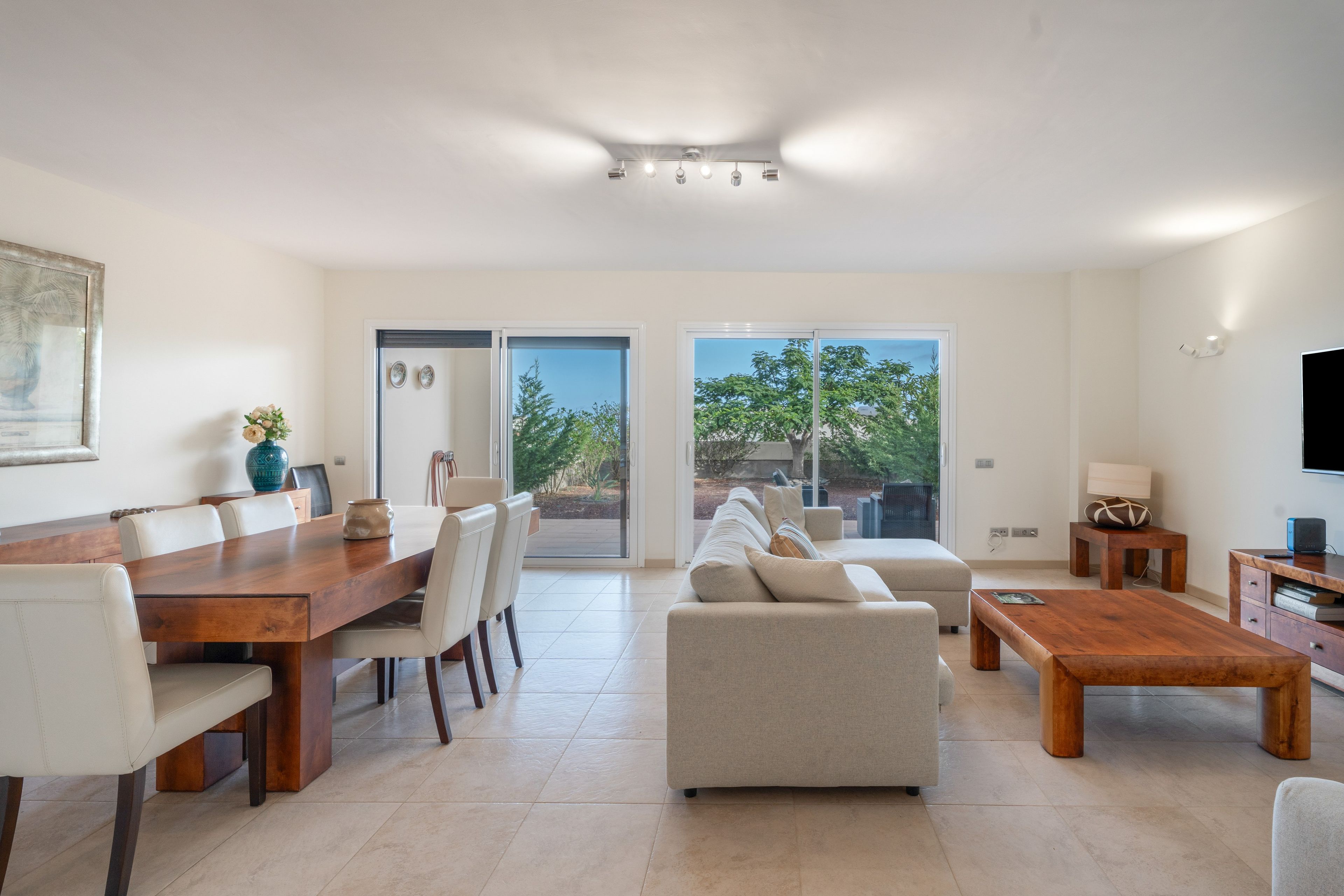 Una sala de estar moderna con comedor, un sofá, una mesa de centro y un televisor.