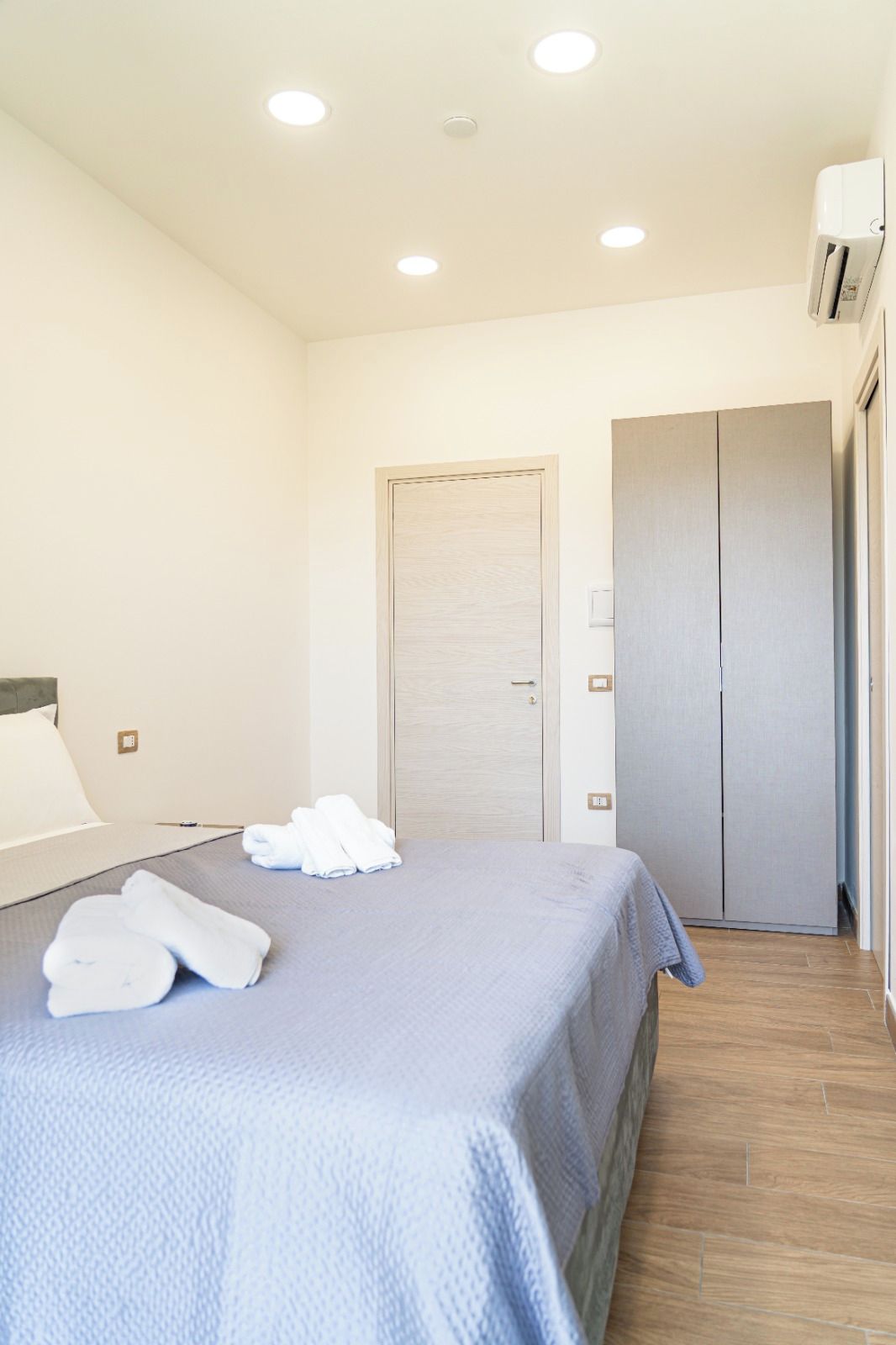 Ein Hotelzimmer mit Bett, Schrank und Tür.