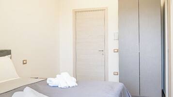 Ein Hotelzimmer mit Bett, Schrank und Tür.
