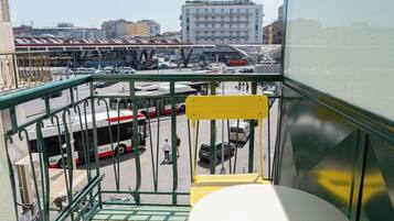 Un balcon donnant sur une gare routière, avec des bâtiments en arrière-plan.