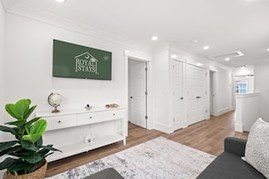 A modern hotel lobby with a green sign, white furniture, a globe, and a potted plant. - The Blue Sky 2 blocks to Beach Pets (Myrtle Beach)