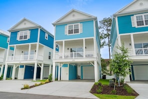A row of two-story townhouses with balconies, garage doors, and a small tree in the front yard. - The Blue Sky 2 blocks to Beach Pets (Myrtle Beach)