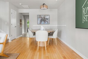 A dining area with a round table, four chairs, and a hanging light fixture. - Rhythm & Tide-Concerts. Coastlines. Charleston. (Charleston)