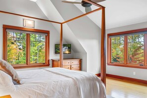 A bedroom with a large bed, a wooden dresser, and a ceiling fan. - 4 Bedroom Stowe Apres Retreat (Stowe)
