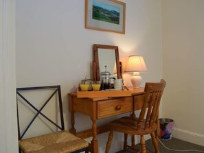 A wooden desk with a mirror, a lamp, and a tray with a coffee pot, mug, and glasses. - Glebe Cottage | 2 Bedroom Cottage in Perthshire (Scone)