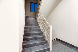 A staircase with a handrail and a window with blue framing.