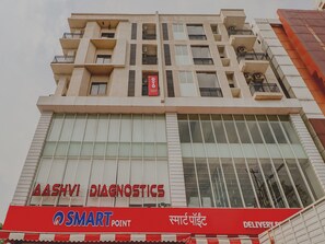 A multi-story building with a sign for 'Aashvi Diagnostics' and a 'Smart Point' delivery service. - Hotel O Hotel Outline (Ranchi)