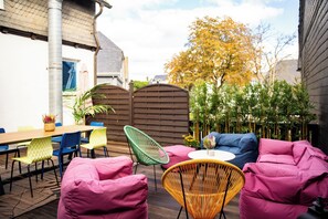 An outdoor seating area with a table and chairs, a wooden fence, and a tree with autumn leaves. - GoodTimes, 189 m², sauna, large balcony, and right in the heart of Winterberg (Winterberg)