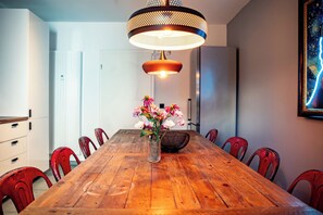 A dining area with a wooden table, red chairs, a vase with flowers, and a pendant light. - GoodTimes, 189 m², sauna, large balcony, and right in the heart of Winterberg (Winterberg)