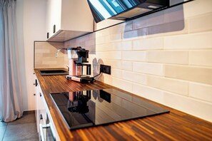 A modern kitchen with a black countertop, a coffee machine, and white tiled walls. - GoodTimes, 189 m², sauna, large balcony, and right in the heart of Winterberg (Winterberg)