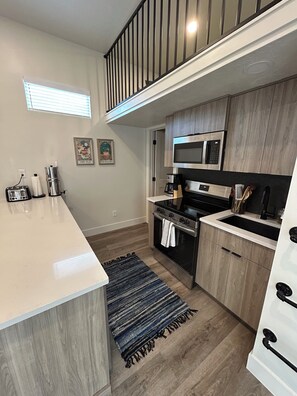 A modern kitchen with a central island, stainless steel appliances, and wooden cabinetry.