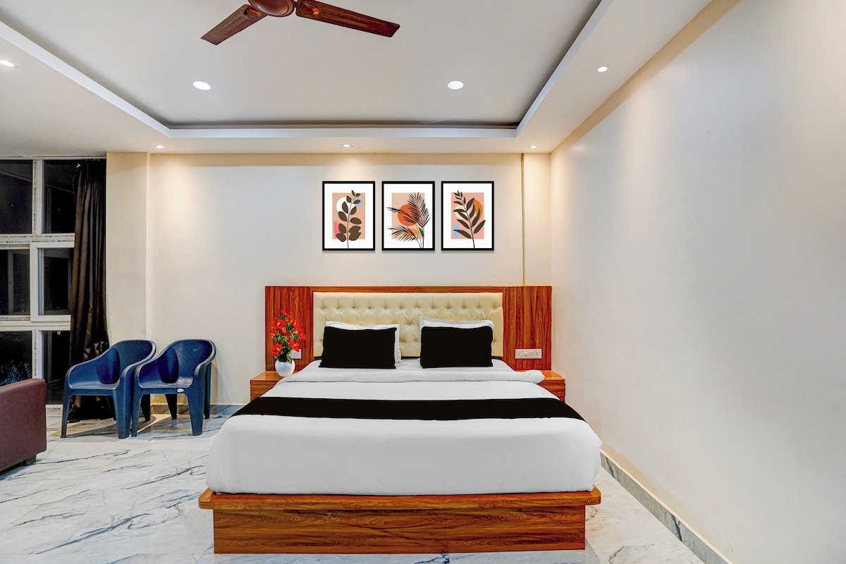 A modern bedroom with a large bed, a ceiling fan, and three framed artworks on the wall.