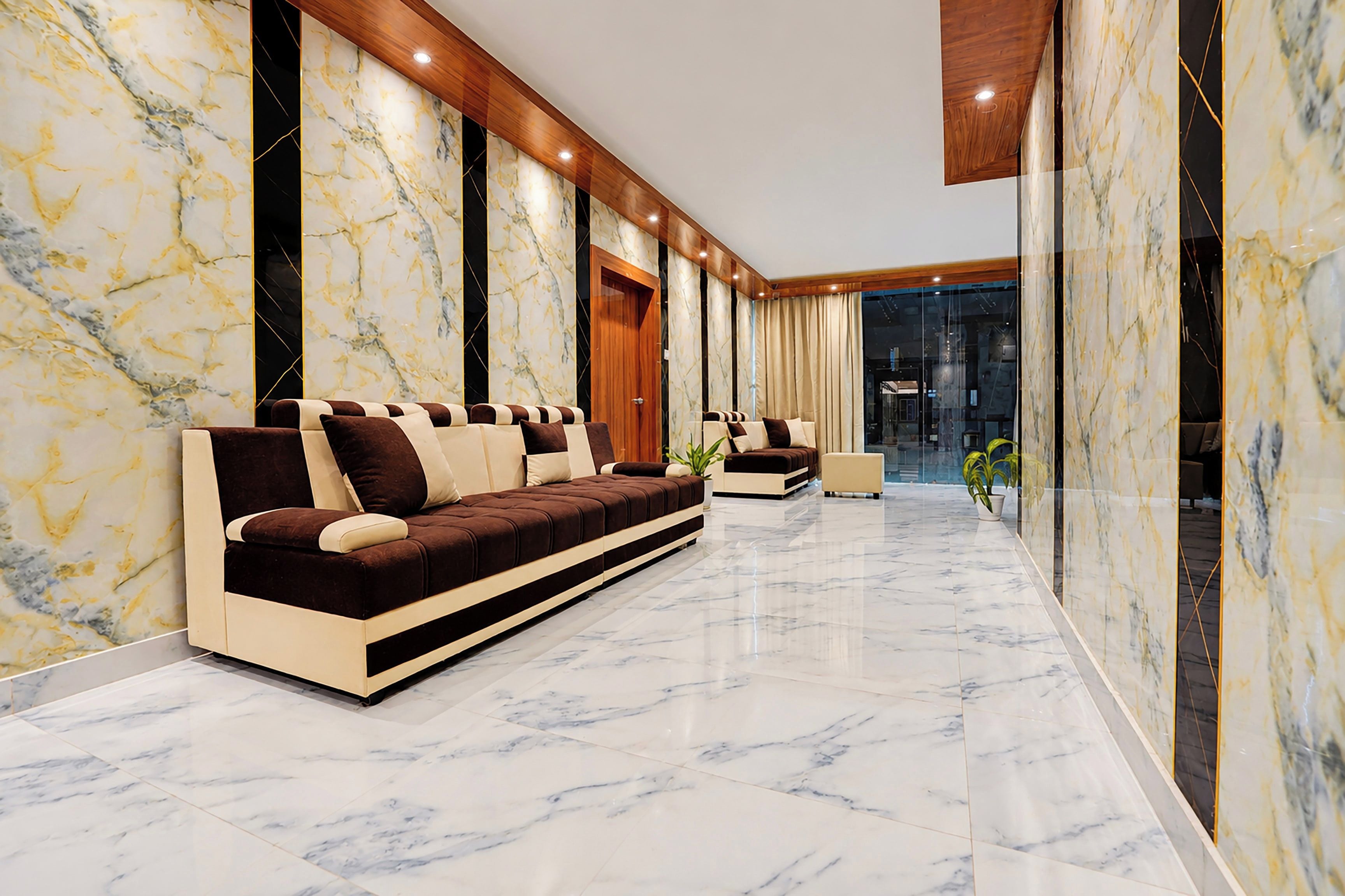 Un interior moderno con piso de mármol, un sofá largo y techo de madera.