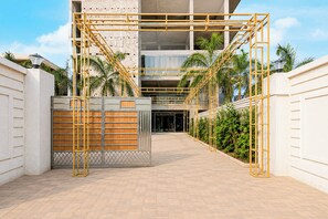 A gated entrance with a metal gate and a wooden fence, leading to a building with a modern architectural style. - Collection O Bindusagar (Bhubaneshwar)