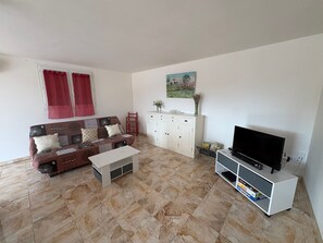 A living room with a sofa, a coffee table, a TV stand, and a cabinet. - Holiday home 'Gîte Les Piboules' with Mountain View, Wi-Fi and Air Conditioning (Caseneuve)