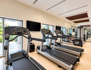 A gym with treadmills, exercise equipment, and large windows. - FIRST CLASS | 1BR | Luxe Burj & City View (Downtown)