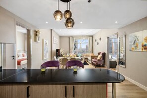 A modern interior with a central island table, dining area, and seating. - FIRST CLASS | 2BR | Prime Location | Skyline Views (Dubai)