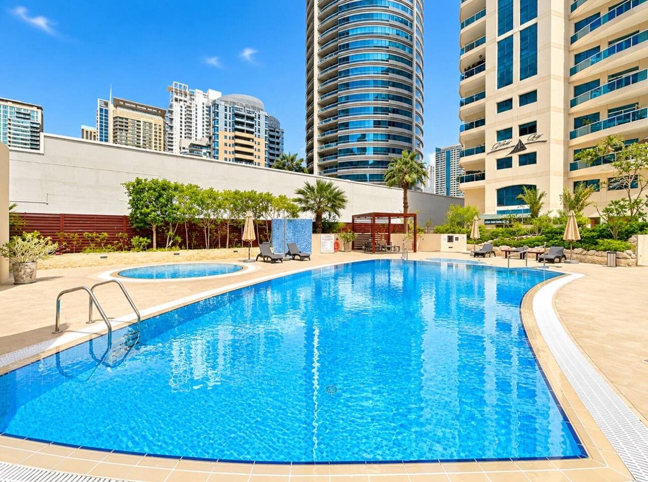 A swimming pool with a cityscape in the background.
