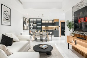A modern living room with a sofa, coffee table, and a TV mounted on the wall. - FIRST CLASS | 2BR | High Floor | Stunning Sea View (Marina)