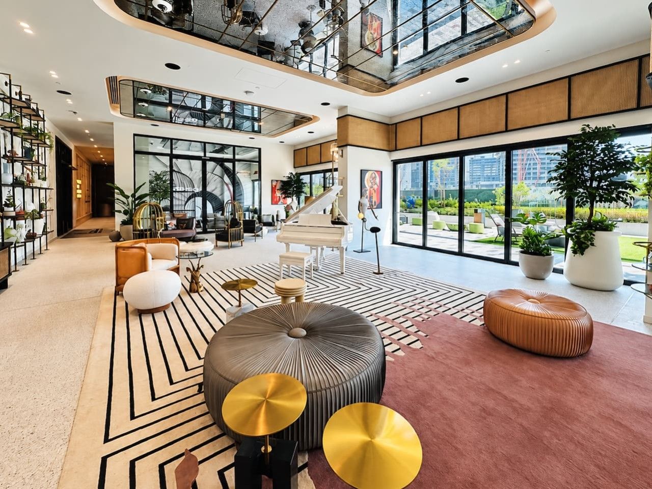 Eine geräumige Lobby mit einem Flügel, einer Treppe und einem großen Fenster mit Blick ins Freie.
