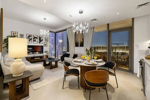 Ett modernt vardagsrum med en matplats, stora fönster och utsikt över stadsbilden.
