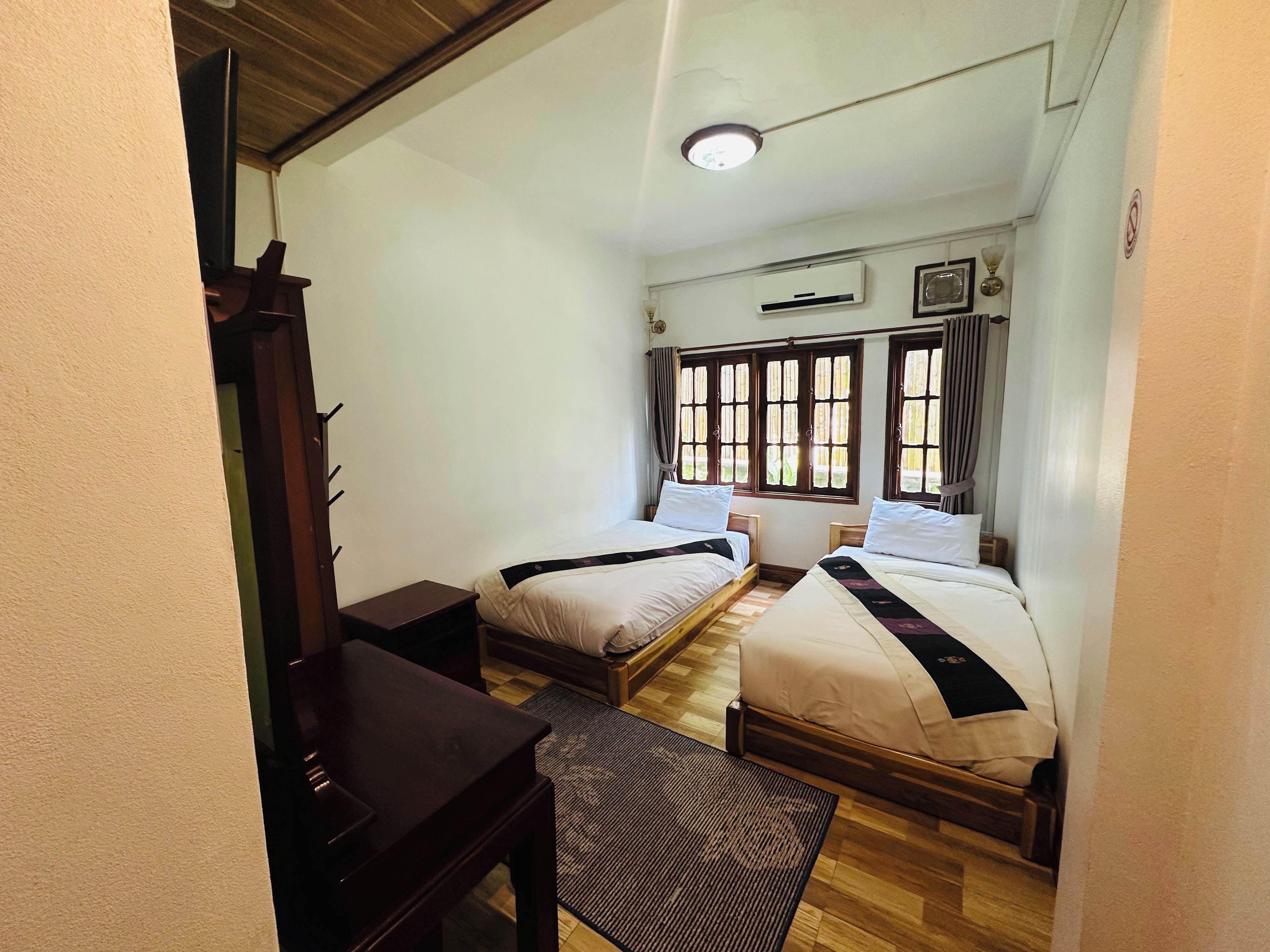 A room with two beds, a desk, and a chair.
