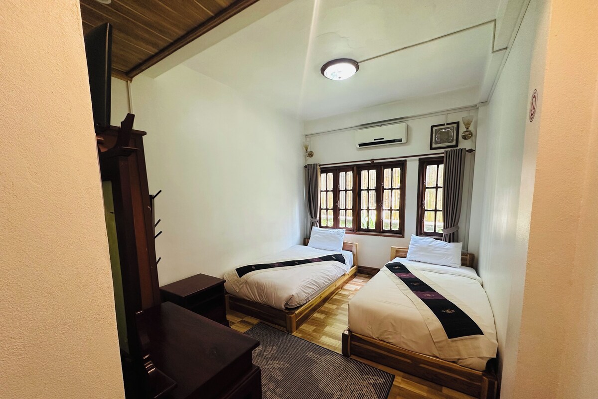 A room with two beds, a desk, and a chair.