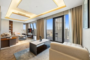 Un salon moderne avec un canapé, une table basse et un téléviseur. Il y a un balcon avec vue sur la ville.