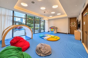 A children's play area with a large window, a playhouse, and bean bags. - FIRST CLASS | 5BR | Burj Khalifa & Fountain Views (Downtown)