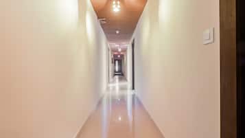 A long, narrow hallway with a wooden ceiling and recessed lighting.