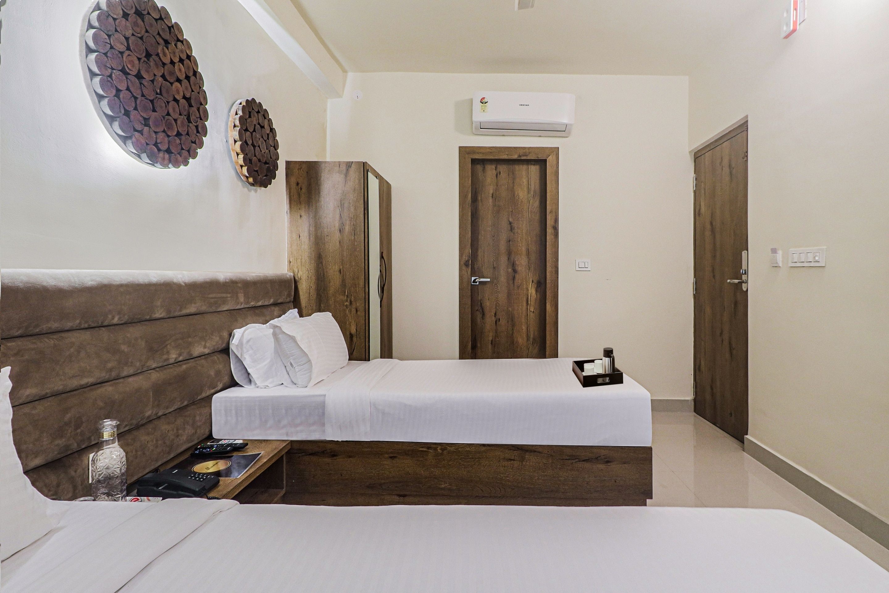 A hotel room with a bed, bedside table, and a wardrobe.