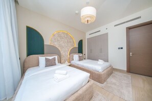 A hotel room with two beds, a wardrobe, a door, and a ceiling light. - FIRST CLASS |3BR| Crest Grande | Chic City Escape (Sobha Hartland)
