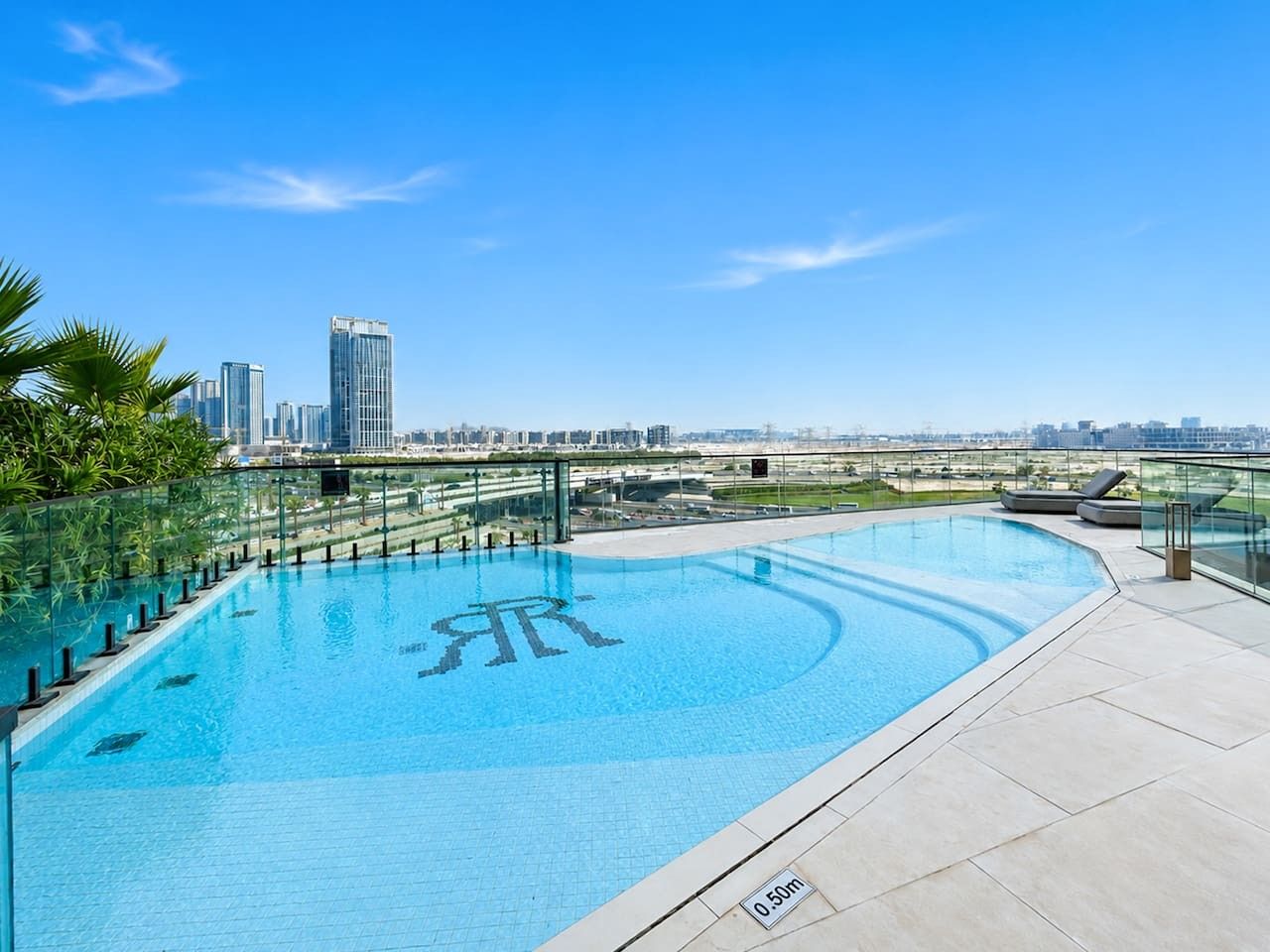 A rooftop swimming pool with a clear view of the city skyline.