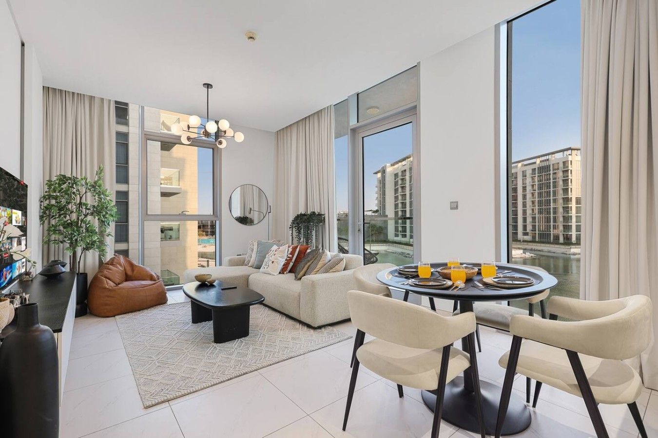 A modern living room with a sofa, coffee table, and dining table set for breakfast.