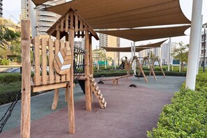 Ein Spielplatz im Freien mit hölzernen Klettergerüsten und Schaukeln.