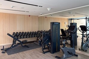 A gym with weightlifting equipment, dumbbells, and cardio machines. - FIRST CLASS | 1BR | JVC Luxe | Modern Living (JVC)