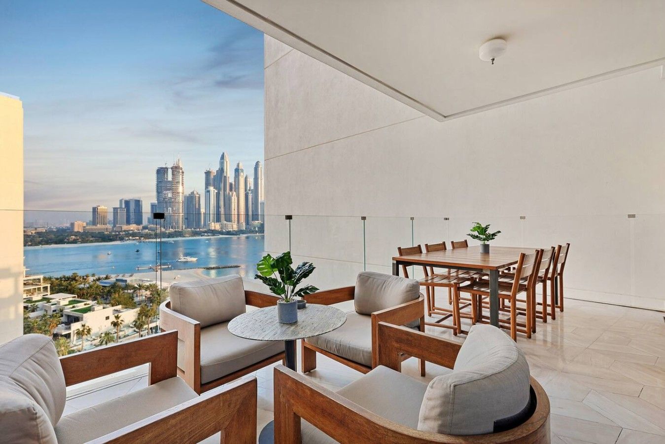 A modern interior with a dining area, seating, and a view of a city skyline and water.