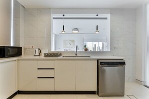 Eine moderne Küche mit Geschirrspüler, Mikrowelle und Spüle.
