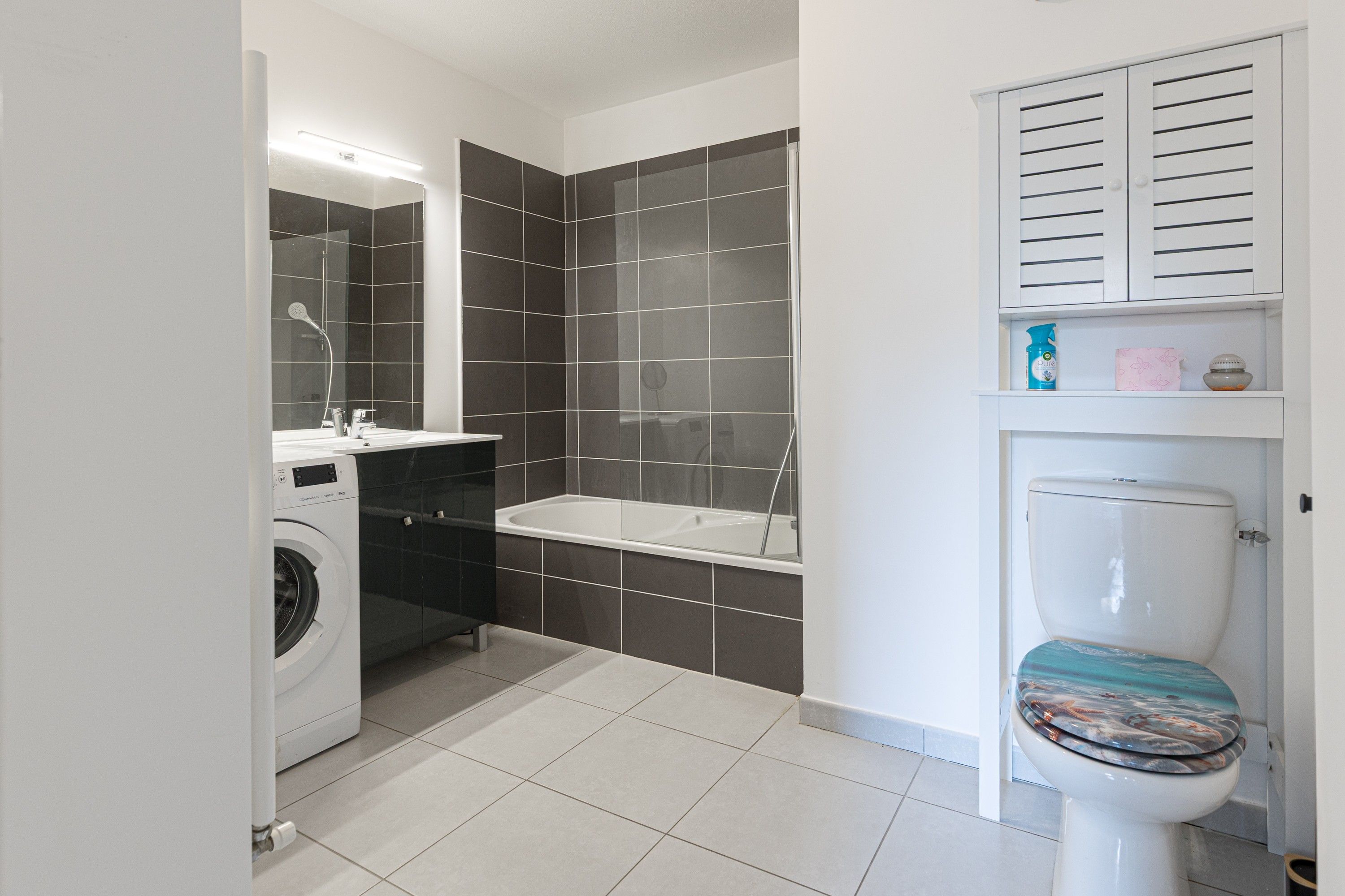 Un baño moderno con lavadora, bañera y retrete.