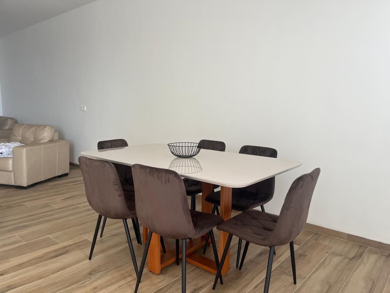 Un comedor con una mesa redonda, seis sillas y un bol en la mesa.