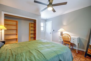 A bedroom with a bed, a desk, a chair, a ceiling fan, and built-in shelving. - 9 Mi to Six Flags! Wooded Retreat w/ Patio (San Antonio)