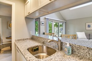 A kitchen with granite countertops, a stainless steel sink, and a view of the outdoor patio. - 2 Mi to Beach! Peaceful Mashpee Hideaway (Mashpee)