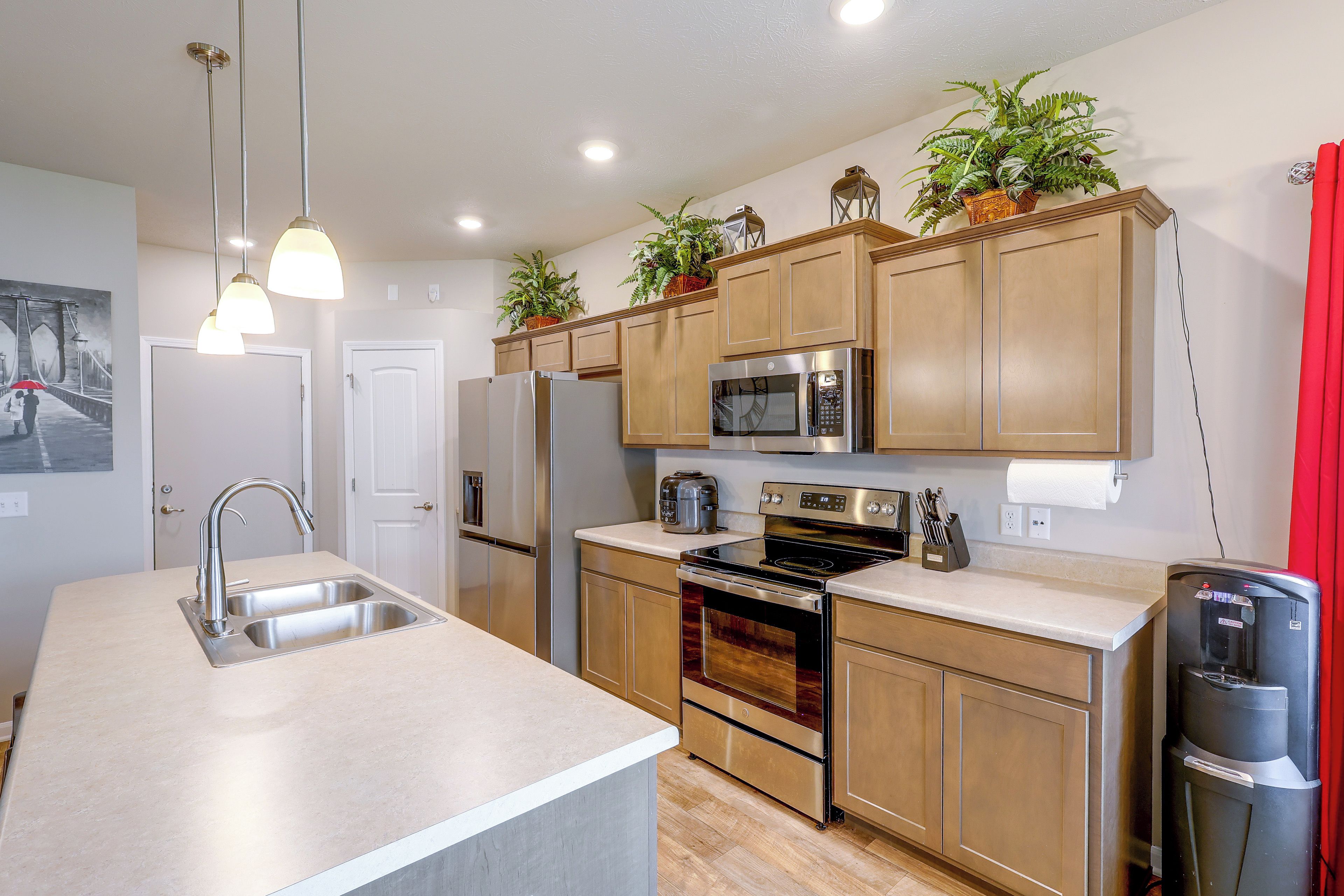 Una cocina moderna con electrodomésticos de acero inoxidable, armarios de madera y una isla central.