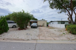 A residential driveway leading to a house with a gravel path, a parked car, and a white fence. - 2 Mi to Universal Orlando! Quiet Studio Suite (Orlando)